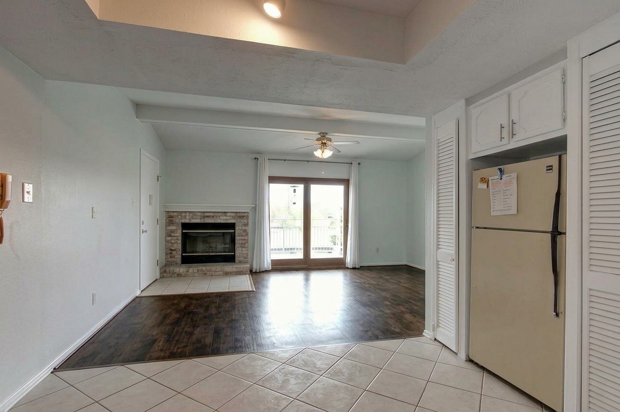 Open living room and kitchen with built-in bookcase and hallway to the bedrooms